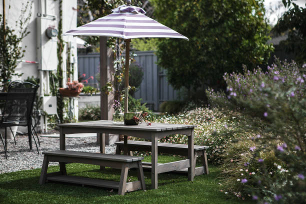 istock Wooden table set in a patio with a parasol 2158510655
