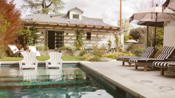 istock Wooden seats by a pool with parasols 2158510660