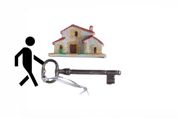 A man is walking towards a house with a key in his hand