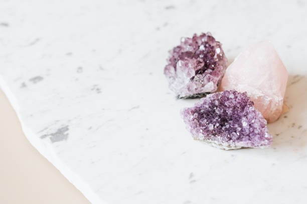 istock Rose quartz and amethyst healing crystals on a marble countertop 2158512547