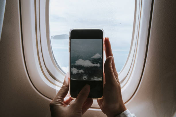 istock Woman capturing clouds from the plane window with her phone 2158512634