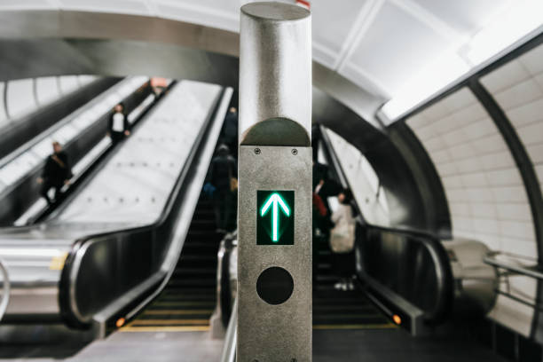 Green up arrow in front of escalators