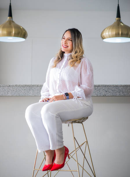 istock young woman sitting on a chair smiling 2158514237