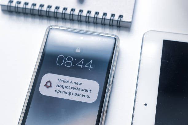 istock Push notification about a hotpot restaurant opening nearby pop up in mobile screen on desk. Push technology by location tracking, business advertising techniques concept. 2158515032