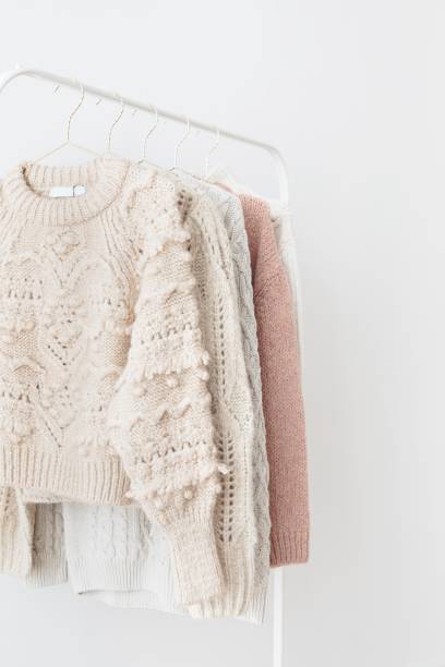 istock Casual knitted sweaters hanging on a rack 2158516402