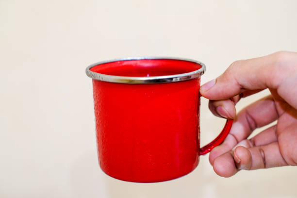 A han holds Iron Red cup of coffe isolated above white background with copy space,caffein, stock drink.