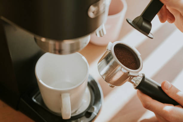 istock Barista pressing ground coffee in a filter coffee of machine 2158517417
