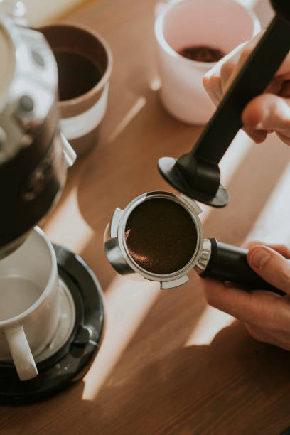 istock Barista pressing ground coffee in a filter coffee of machine 2158517419