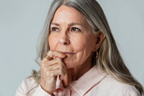 istock Thoughtful senior woman against a gray background 2158517443