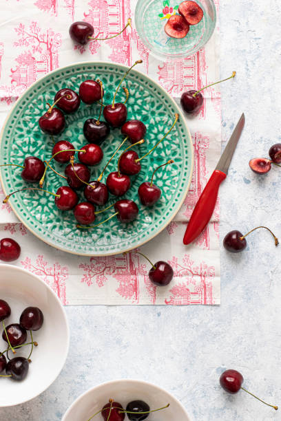 istock Fresh ripped red cherries on a green plate flatlay 2158518961