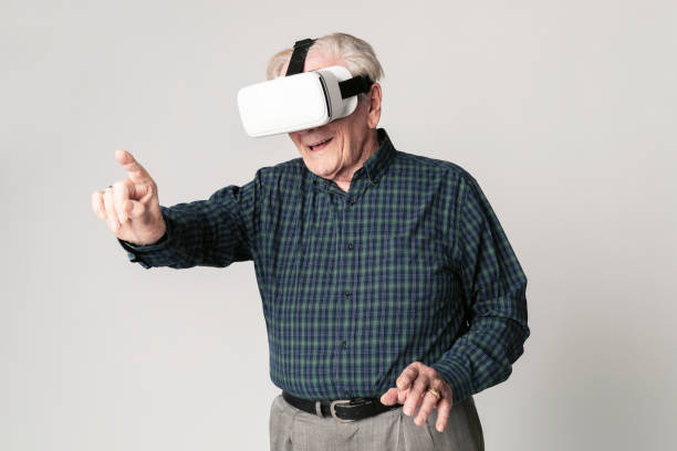 istock Cheerful senior man wearing virtual reality goggles 2158519259