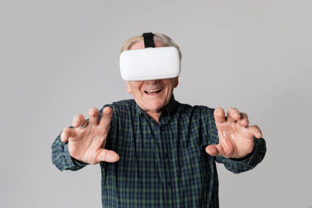 istock Cheerful senior man wearing virtual reality goggles 2158519311