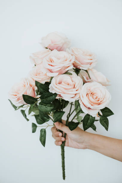 istock Hand holding a bouquet of light orange roses 2158520973