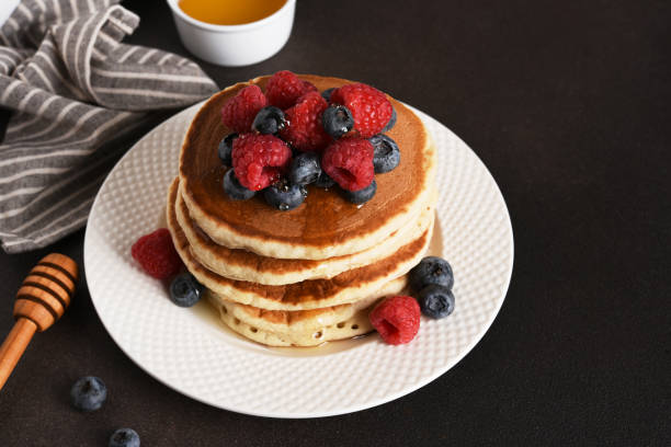 istock Homemade pancakes with berries on a dark background 2158521557