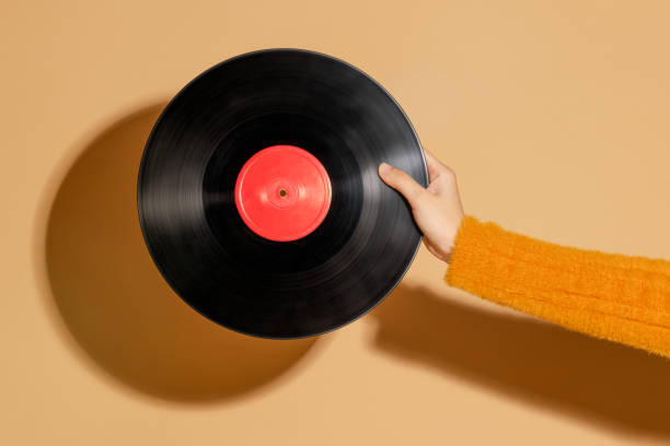 istock Woman holding a vinyl record on a beige background 2158524559