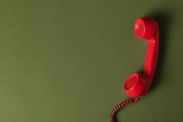 Retro red corded phone on an olive green background