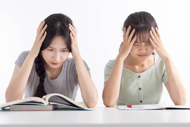 istock tired upset student girls grabbing head 2158527857