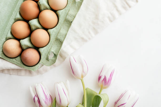 istock Easter eggs in a green carton and tulips flatlay 2158528883