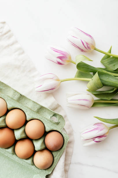 istock Easter eggs in a green carton and tulips flatlay 2158528887