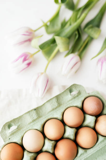istock Easter eggs in a green carton and tulips flatlay 2158528893