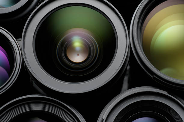 Bunch of black camera lenses with colorful reflections. Can be used as a background.