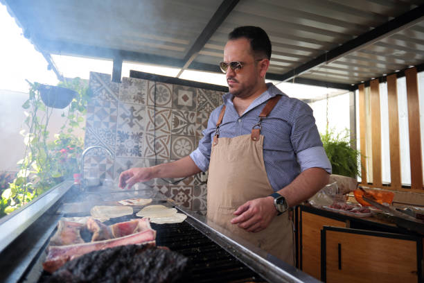 istock Young man cooks charcoal-grilled meat at home 2158533410