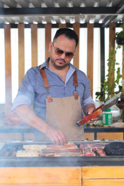 istock Man places meat on the grill 2158533464