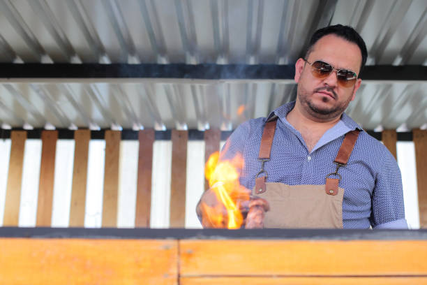 Man turns the meat on the grill