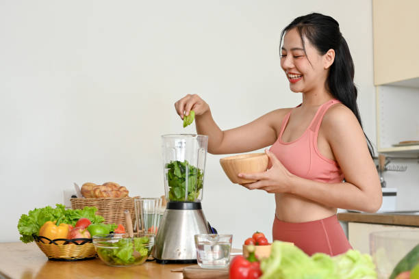 istock young woman making smoothie with fresh vegetables in kitchen. 2158533497