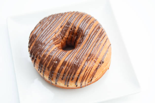 Chocolate frosted donut with sprinkles isolated on a white background.