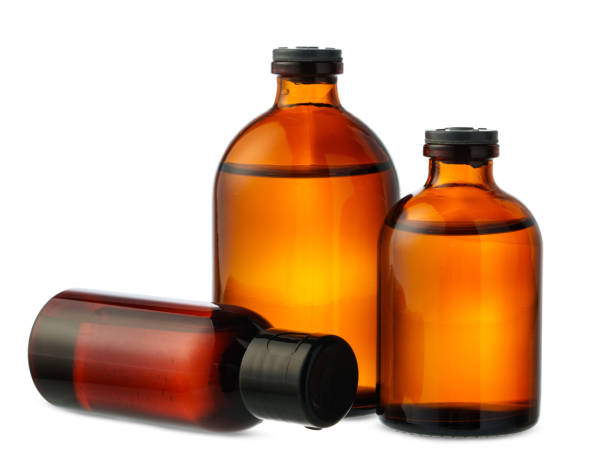 istock Three Amber Glass Bottles Filled With Liquid on White Background 2158534342