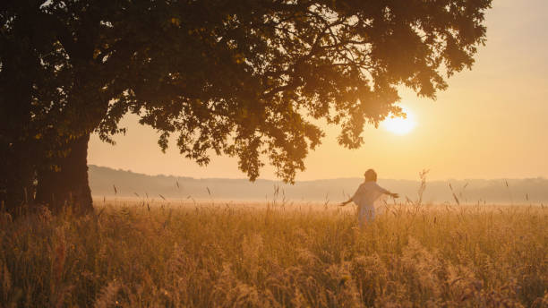 istock Serene Woman Enjoying Sunset by an Ancient Oak 2158534513