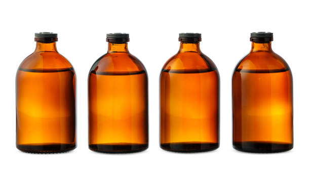 istock Four Amber Glass Bottles With Black Caps on a White Background 2158534647
