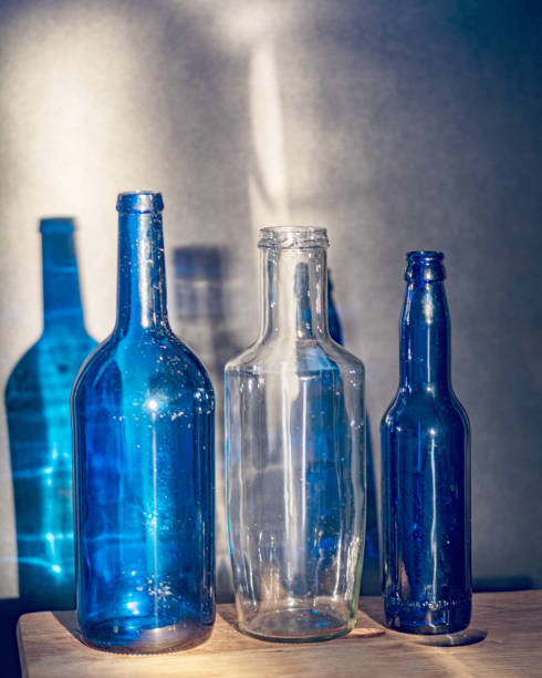 istock Still life with blue glass bottles, quiet shadows in the background, soft evening light 2158536515