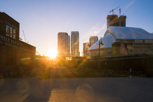 Rogers centre and CN tower at sunset time. Baseball stadium and new modern skyscrapers. Architecture of downtown Toronto, Ontario, Canada