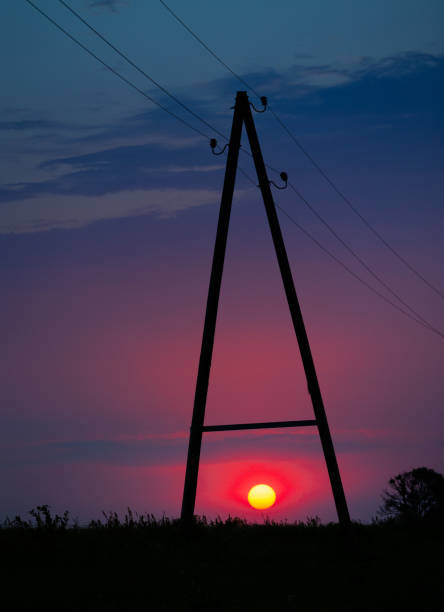 A beautiful red sun disc rising above the horizon. Natural scenery of summer in rural Latvia, Northern Europe.