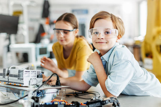 istock Two classmates working togeter on circuit board, building robot in after-school robotics club. Children learning robotics in Elementary school. 2158536764