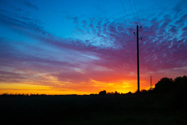 A beautiful summer sunrise in rural Latvia. Bright morning sky with dark foreground.