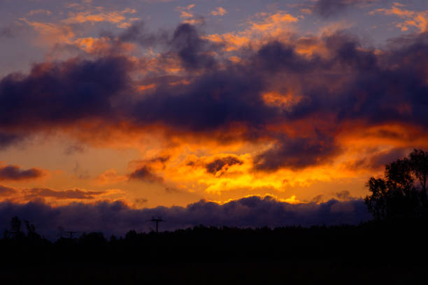 A beautiful summer sunrise in rural Latvia. Bright morning sky with dark foreground.
