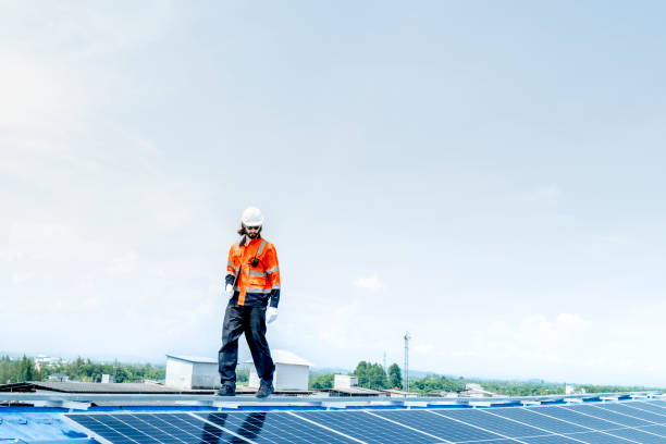 istock engineer man inspects construction of solar cell panel or photovoltaic cell by electronic device. Industrial Renewable energy of green power. factory worker working on tower roof. 2158538881