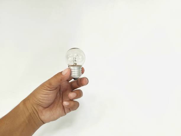 istock Hand holding a light bulb isolated in white background 2158539456