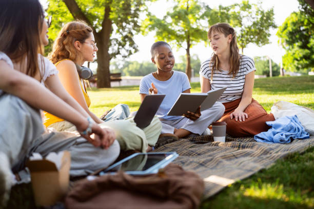 istock Multiracial female University students studying together at the campus park 2158539868