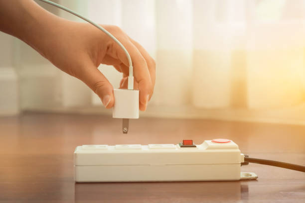 istock Close-up of electrician's hand using red push button to turn on the power strip,Save electricity by turning off the human finger on the red button on the electrical plug. 2158540302