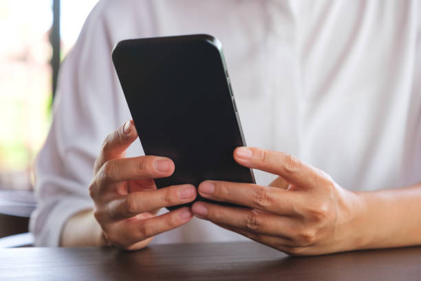 istock Closeup image of a woman holding and using mobile phone 2158542244