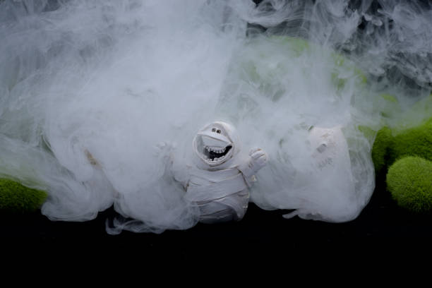 Small funny horror figures with strange graveyard with fog and green mossy mounds Thailand Asia Made and designed by Photographer