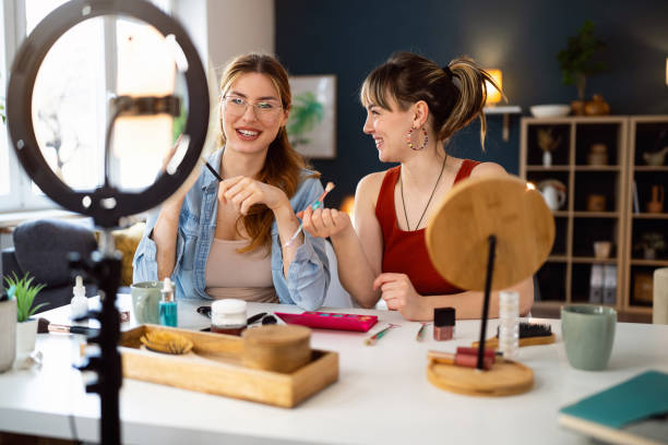 istock Two young women, influencers, recording a make-up tutorial for their vlog. 2158547802