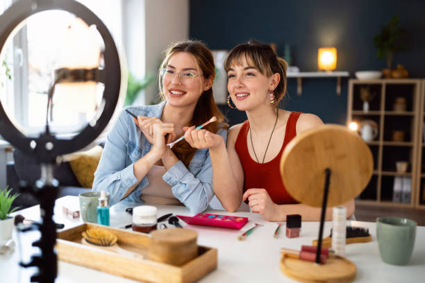 istock Two young women, influencers, recording a make-up tutorial for their vlog. 2158547815