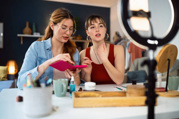 istock Two young women, influencers, recording a make-up tutorial for their vlog. 2158548107