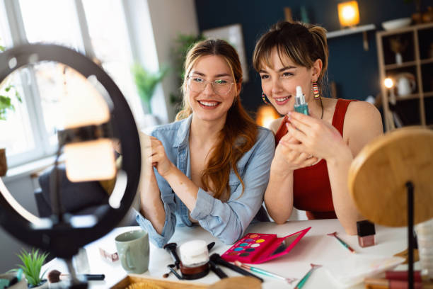 istock Two young women, influencers, recording a make-up tutorial for their vlog. 2158548200