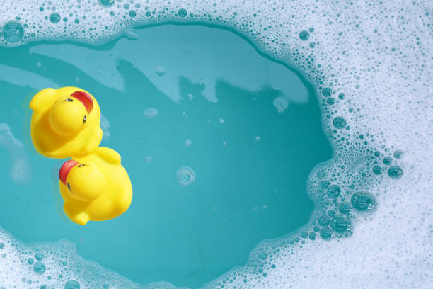 istock Yellow rubber ducks in water with soap foam 2158549126